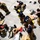 An overhead view of a group of firefighters on a concrete surface, appearing to be suiting up or conducting equipment checks. Multiple personnel are seen donning or handling firefighting gear including SCBA (Self-Contained Breathing Apparatus) tanks, turnout gear, and helmets. The scene suggests a training exercise or pre-deployment preparation.