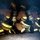 Multiple firefighters in full turnout gear are crouched low to the ground in a smoke-filled environment, likely during a training exercise or active fire response. They are equipped with SCBA (Self-Contained Breathing Apparatus) tanks on their backs and wearing yellow helmets and reflective-striped bunker gear. Name tags visible on the gear include 'NAKANOAK' and 'TERUY' (partially obscured).
