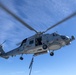 An MH-60R Seahawk assigned to the “Warlords” of Helicopter Maritime Strike Squadron (HSM-51) prepares to conduct a helo in-flight refueling (HIFI)