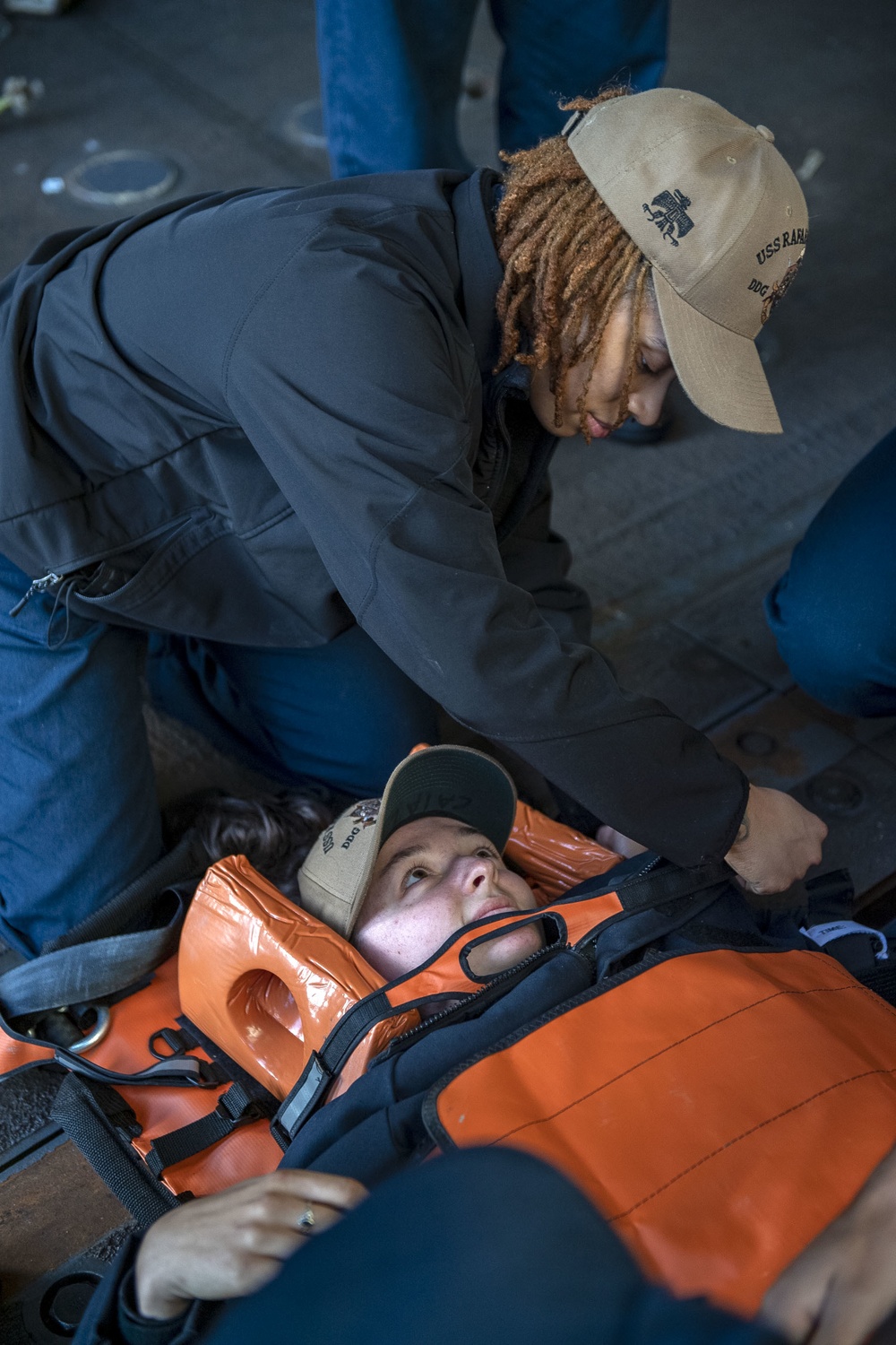 Culinary Specialist 3rd Class Shayla Collins, from New Orleans, La., secures Aviation Electronics Mate 2nd Class Bethany Caiazza, from Wichita, Kan., into a Reeve’s sleeve stretcher