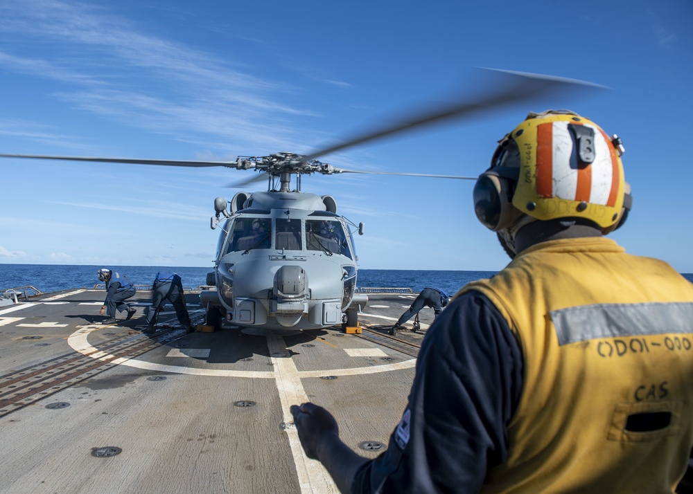 Sailors secures chocks and chains to an MH-60R Seahawk