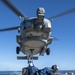 Sailors withdraw from equipment secured to an MH-60R Seahawk