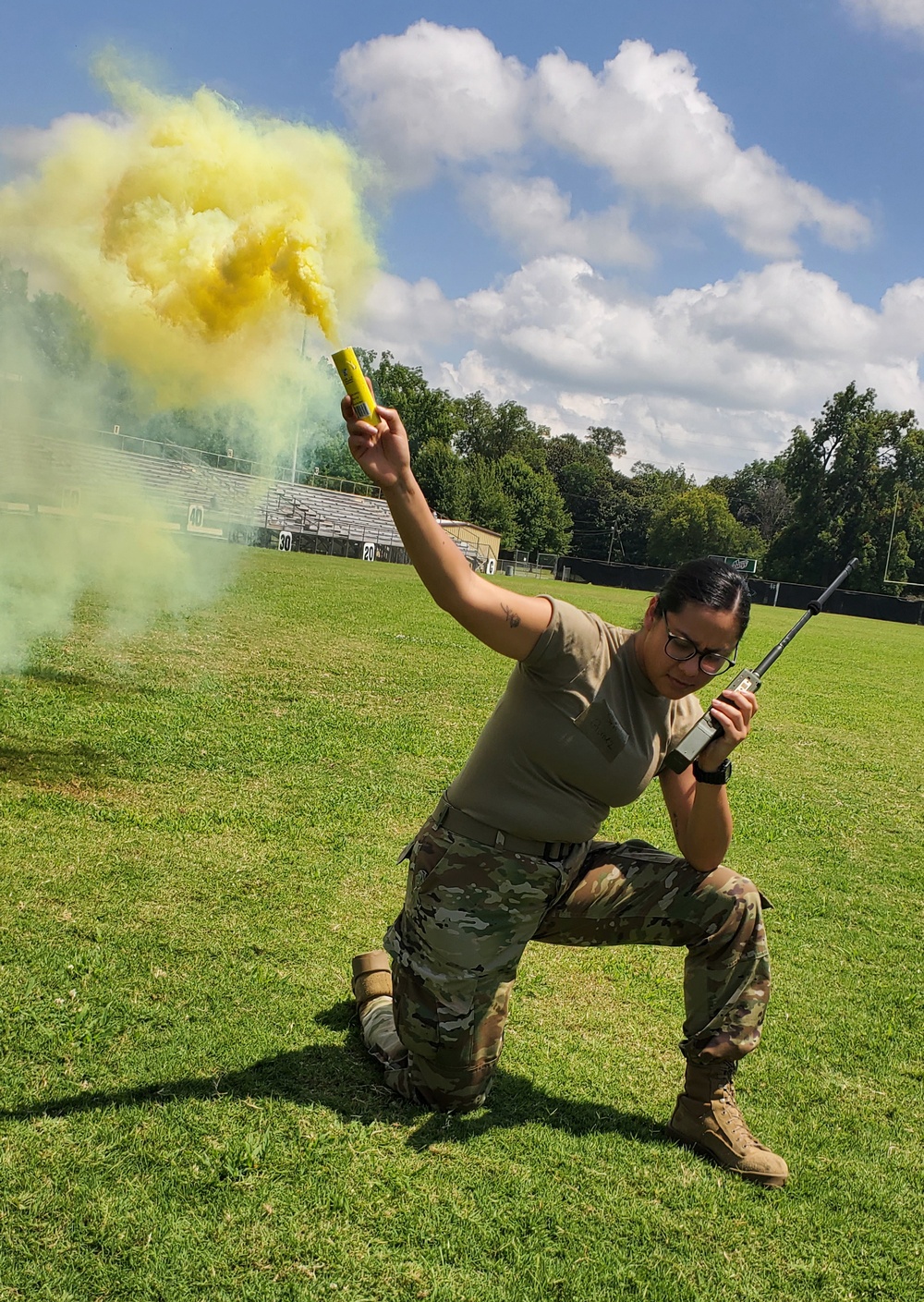 Senior Airman Rubella Gomez demonstrates the use of a smoke grenade and proper radio techniques