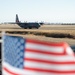 A California Air National Guard C-130 taxis to the runway at McClellan Air Tanker Base, Sacramento, Calif. as the U.S. Flag waves in the wind