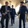 Acting SecAF Roth visits Joint Base Andrews Three men are walking and conversing under a covered outdoor walkway at what appears to be a military installation. Two individuals are wearing dark blue US Air Force uniforms, while the third is dressed in civilian business attire. The group appears to be engaged in a friendly, informal interaction, with smiles visible on their faces.