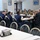 Acting SecAF Roth visits Joint Base Andrews A group of military personnel in various uniforms are seated around tables in what appears to be a dining facility or conference room. A civilian in a dark suit is speaking to the group, gesturing with his hands, suggesting a briefing or leadership engagement session. The attendees include personnel in both Army combat uniforms (OCP) and Air Force dress blues.