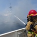 Coast Guard Cutter Benjamin crew members work to extinguish a vessel fire off the San Diego coast