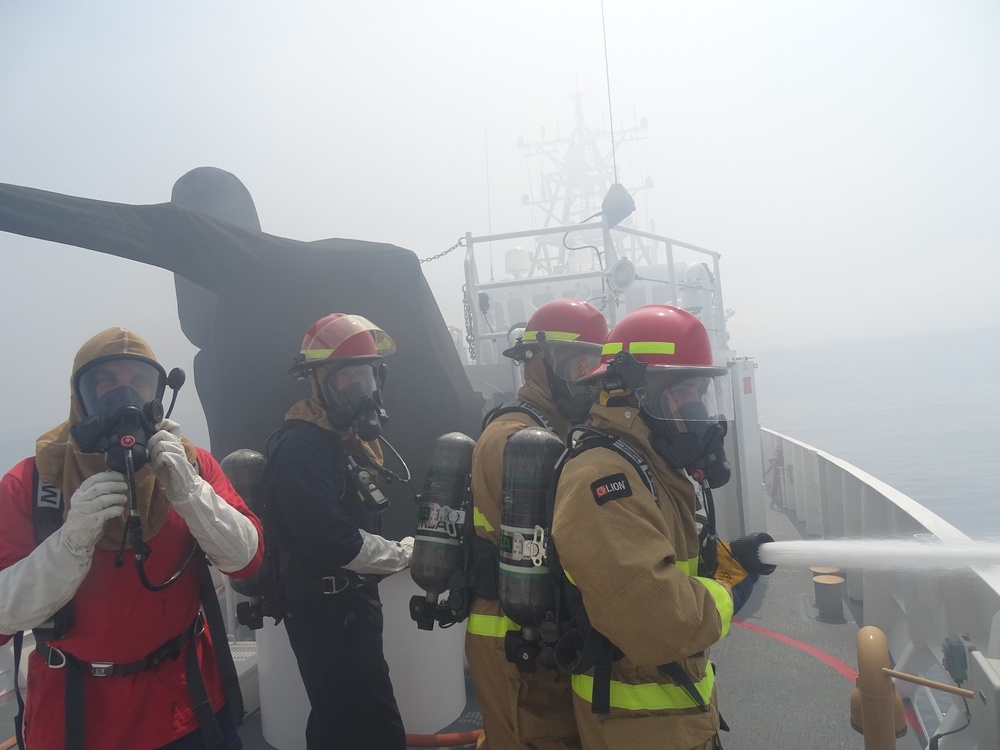 Coast Guard Cutter Benjamin crewmembers work to extinguish a vessel fire off the San Diego coast