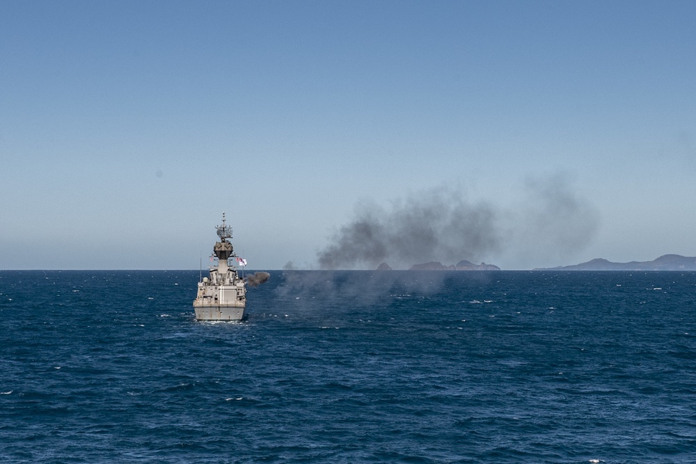 HMAS Ballarat (FFH 155) fires its 5-inch gun for Naval Surface Fire Support from aboard USS Rafael Peralta (DDG 115) during Exercise Talisman Sabre 21