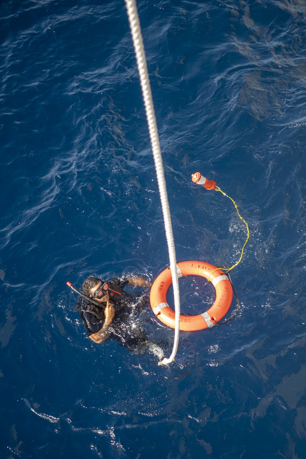 Boatswain’s Mate 3rd Class Martin Sadler, from San Louis Obispo, Calif., retrieves a life ring during Search and Rescue (SAR) swimming operations