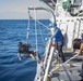 Sailors aboard USS Rafael Peralta (DDG 115) lower Boatswain’s Mate 3rd Class Martin Sadler, from San Louis Obispo, Calif., into the water