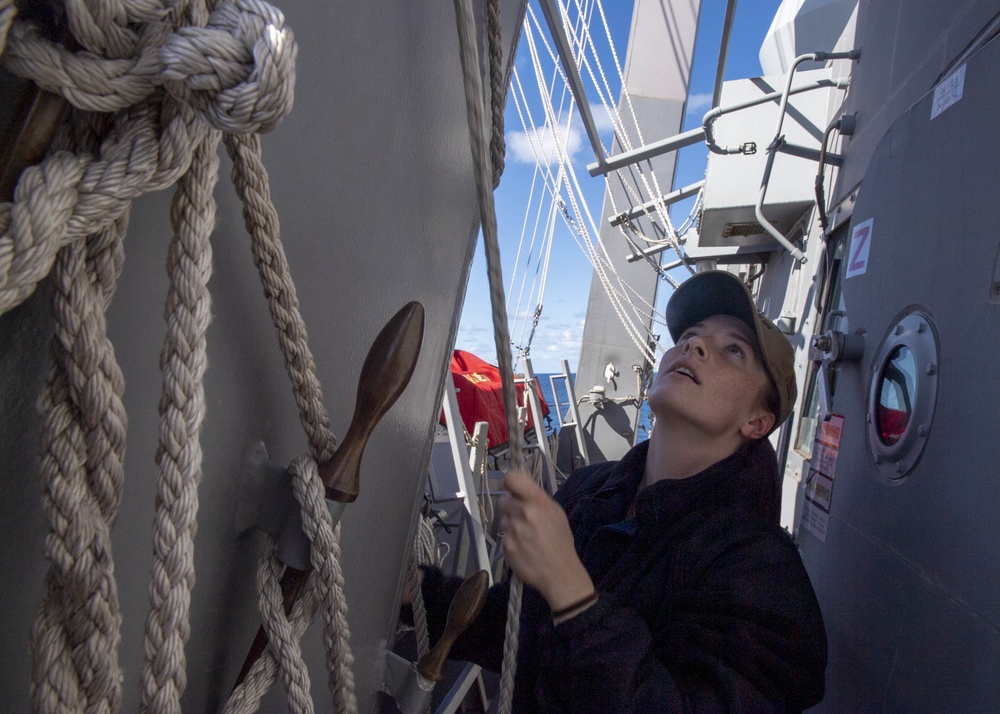 Quartermaster 3rd Class Jordan Boucher, from Worcester, Mass., hoists the Golf flag