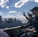 Cmdr. J.J. Murawski (front), commanding officer and Cmdr. Charles Cooper (back), executive officer wave to the crew of the HMAS Brisbane (FFH 41) as they sail alongside aboard USS Rafael Peralta (DDG 115) during Exercise Talisman Sabre 21