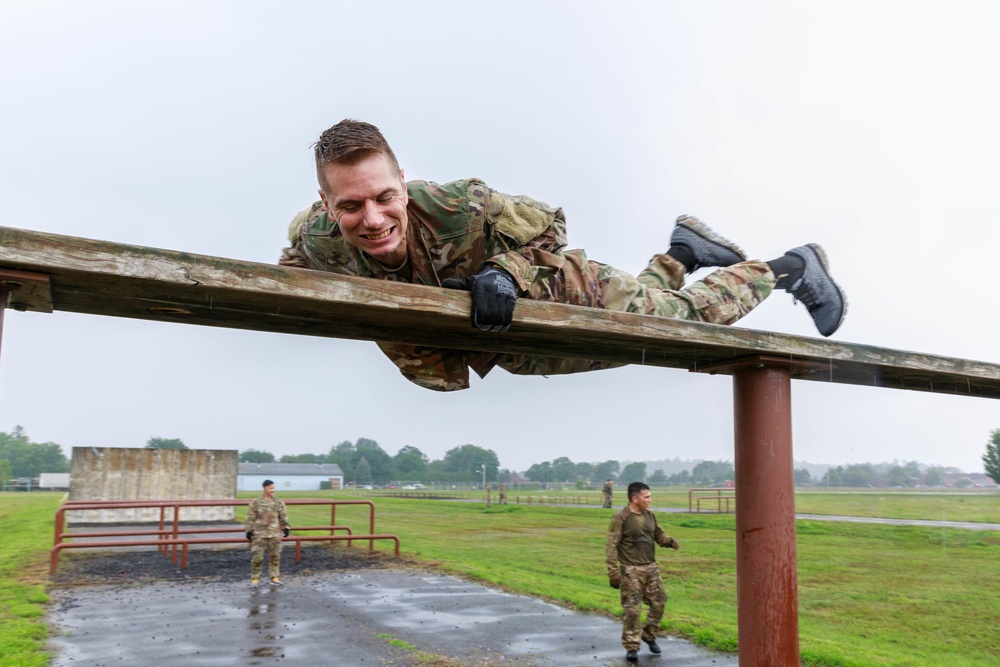 Maj. James Fink climbs over an obstacle