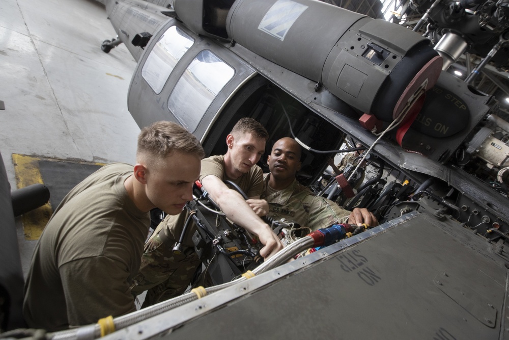 UH-60 Black Hawk helicopter repairers working on aircraft.