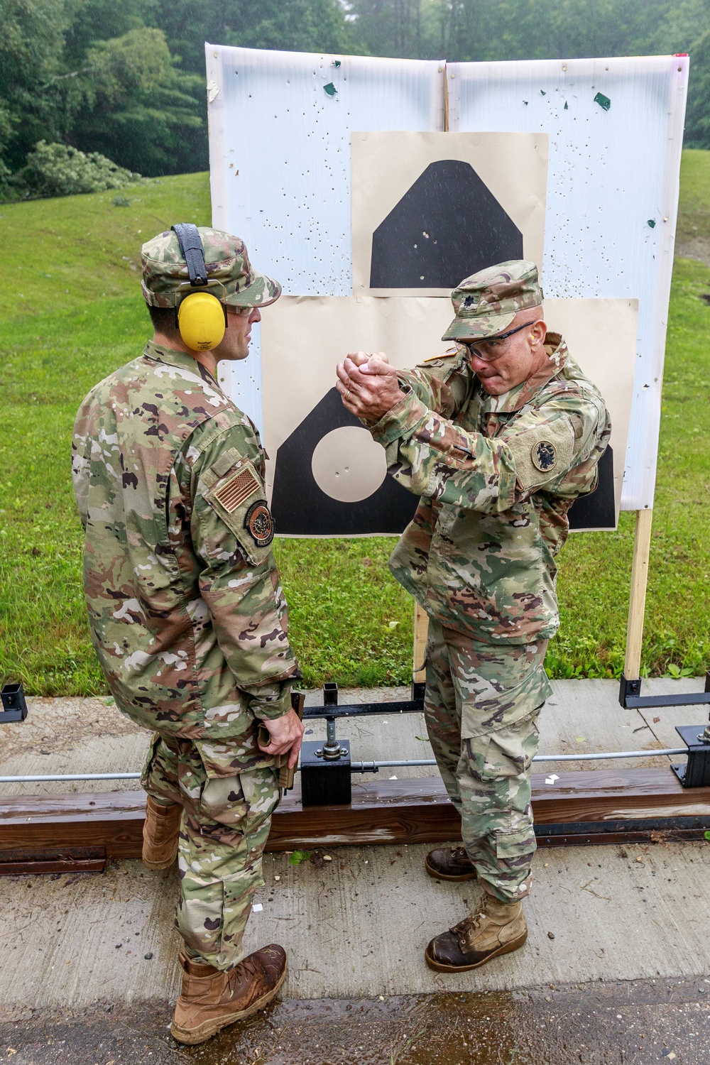 Lt. Col. Daryl Remick teaches Staff Sgt. Trevor Thompson  pistol shooting techniques