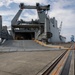 Personnel with the 836th Transport Battalion load cargo onto USNS Fisher
