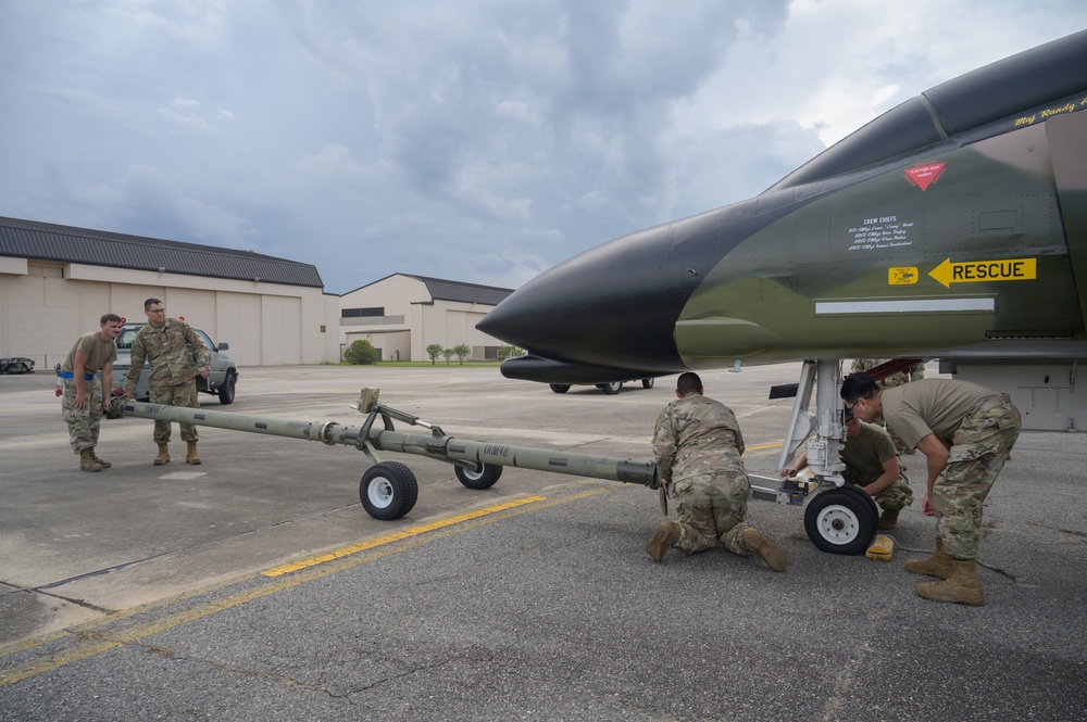 Team JSTARS maintainers tow an F-4C Phantom II to wing HQ for permanent static display