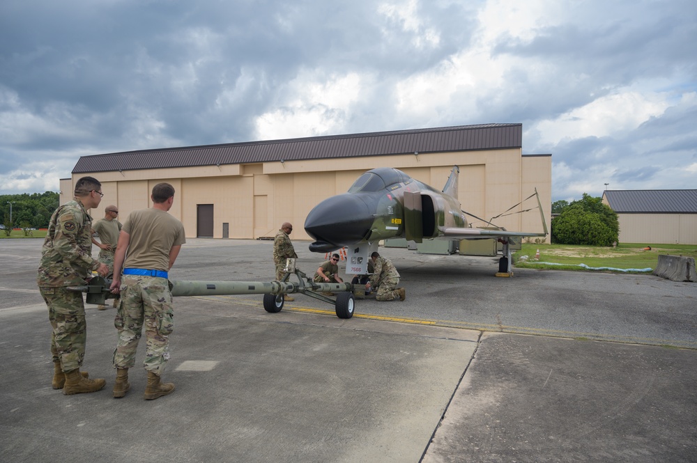 Team JSTARS maintainers tow an F-4C Phantom II to wing HQ for permanent static display