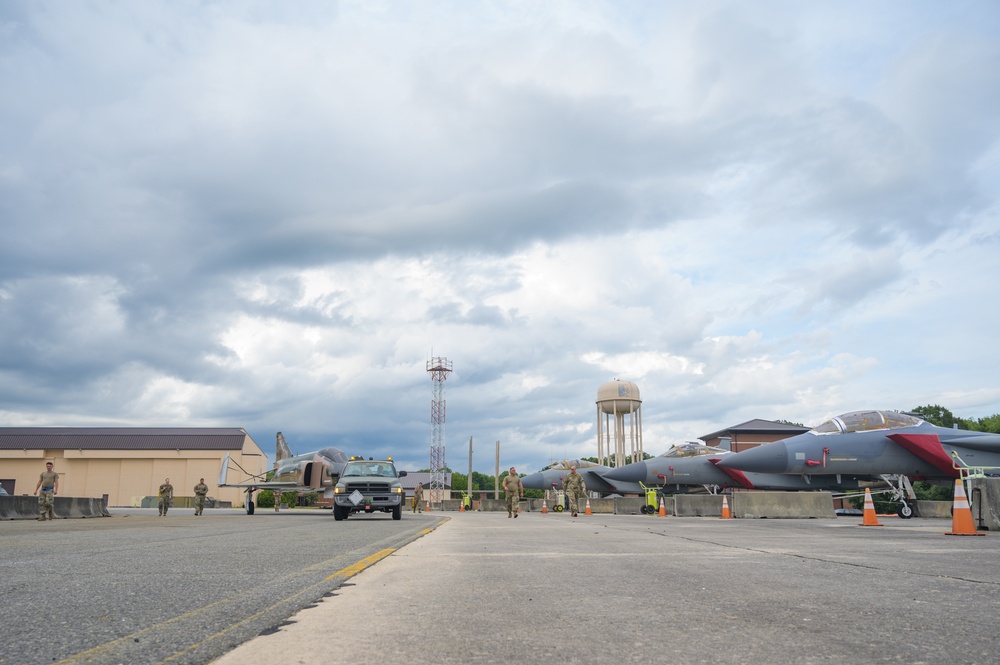 Team JSTARS maintainers tow an F-4C Phantom II to wing HQ for permanent static display