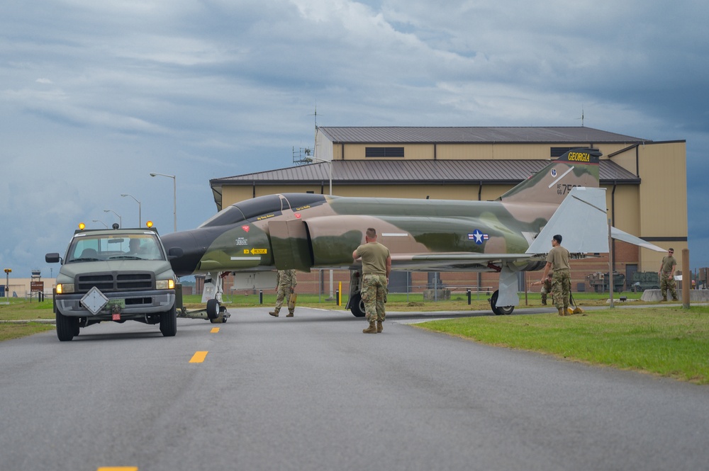 Team JSTARS maintainers tow an F-4C Phantom II to wing HQ for permanent static display