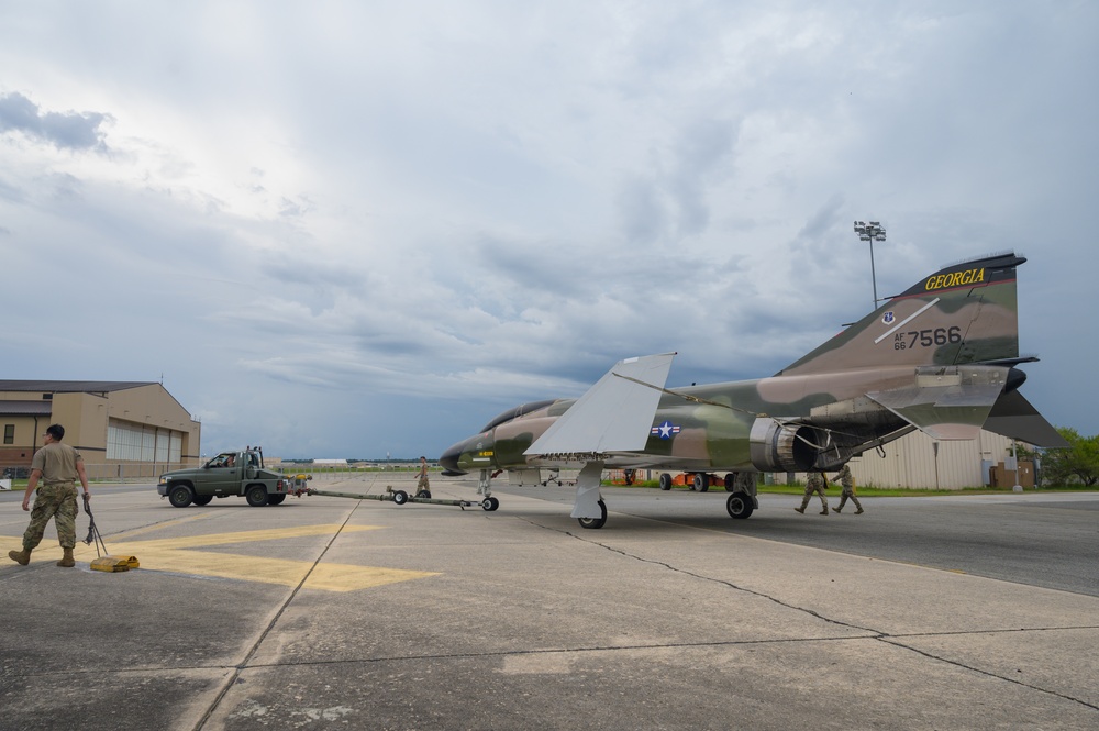 Team JSTARS maintainers tow an F-4C Phantom II to wing HQ for permanent static display