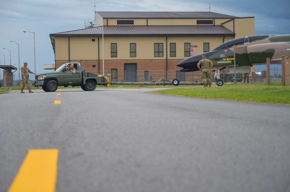 Team JSTARS maintainers tow an F-4C Phantom II to wing HQ for permanent static display