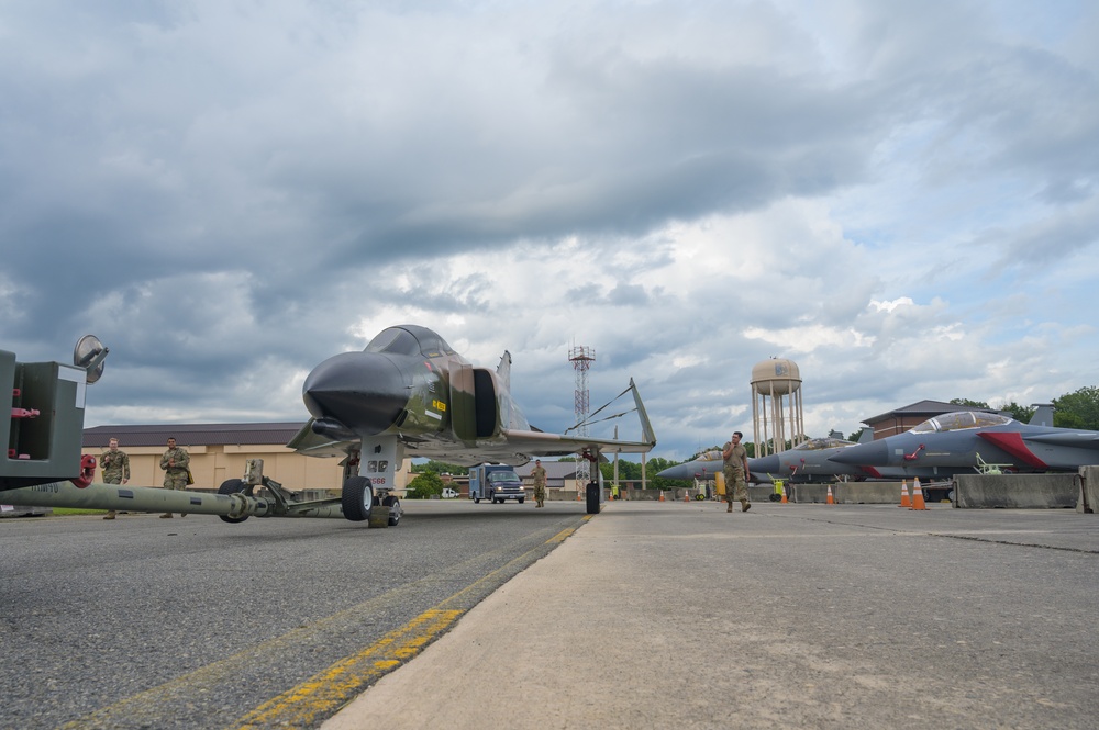 Team JSTARS maintainers tow an F-4C Phantom II to wing HQ for permanent static display