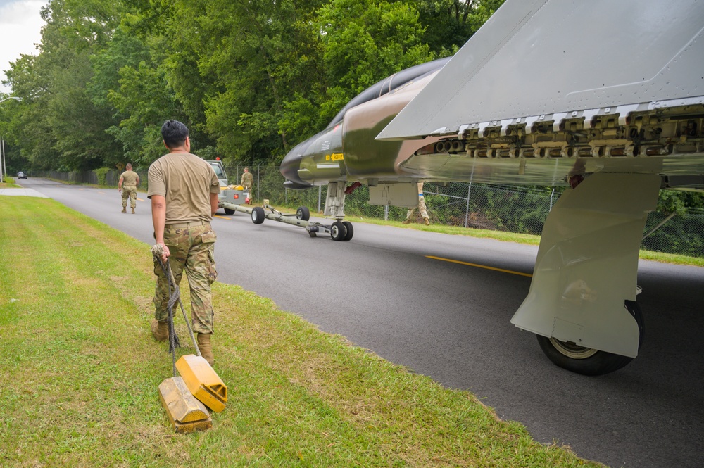 Team JSTARS maintainers tow an F-4C Phantom II to wing HQ for permanent static display