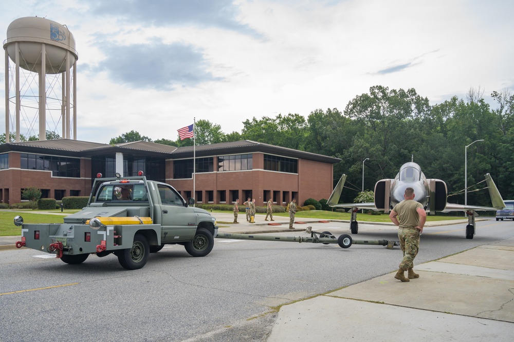 Team JSTARS maintainers tow an F-4C Phantom II to wing HQ for permanent static display