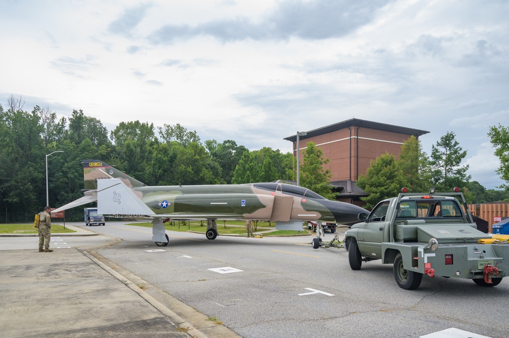 Team JSTARS maintainers tow an F-4C Phantom II to wing HQ for permanent static display