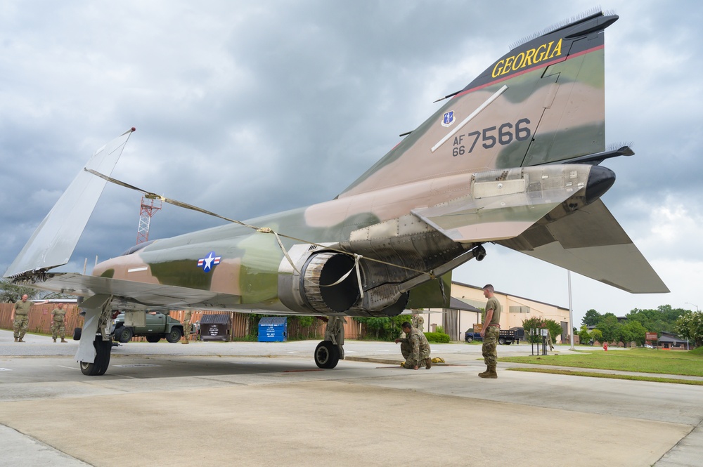 Team JSTARS maintainers tow an F-4C Phantom II to wing HQ for permanent static display