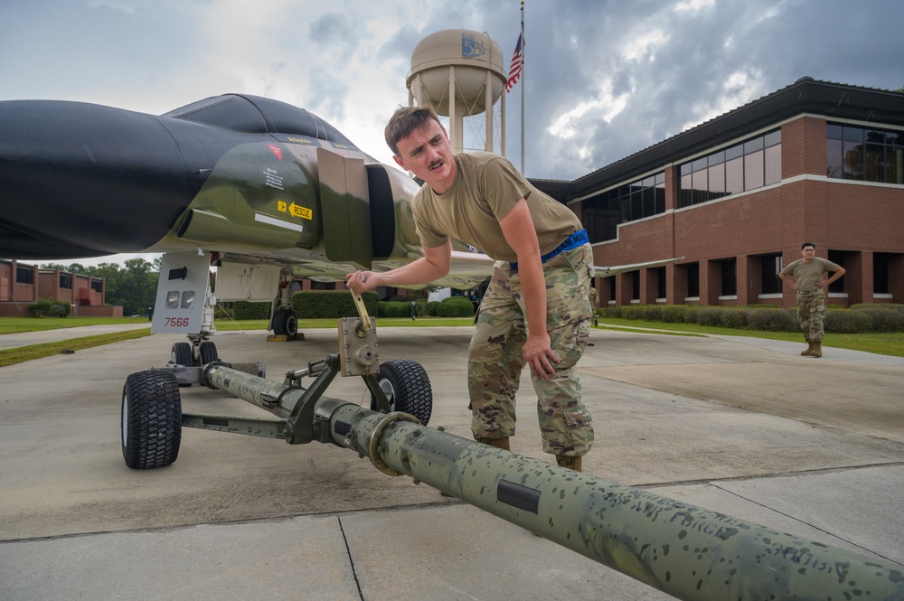 Team JSTARS maintainers tow an F-4C Phantom II to wing HQ for permanent static display