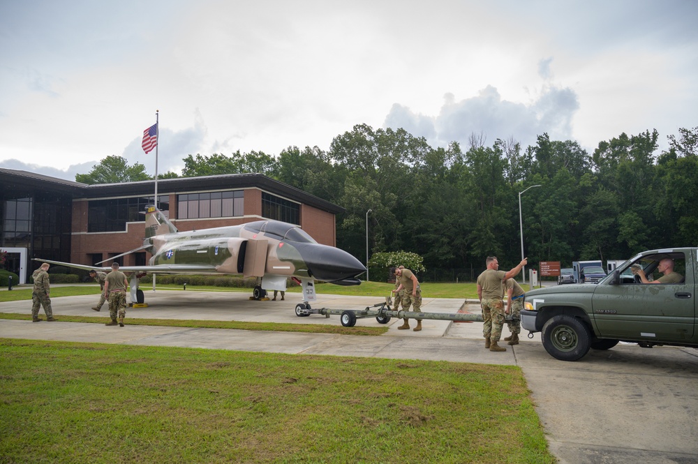 Team JSTARS maintainers tow an F-4C Phantom II to wing HQ for permanent static display