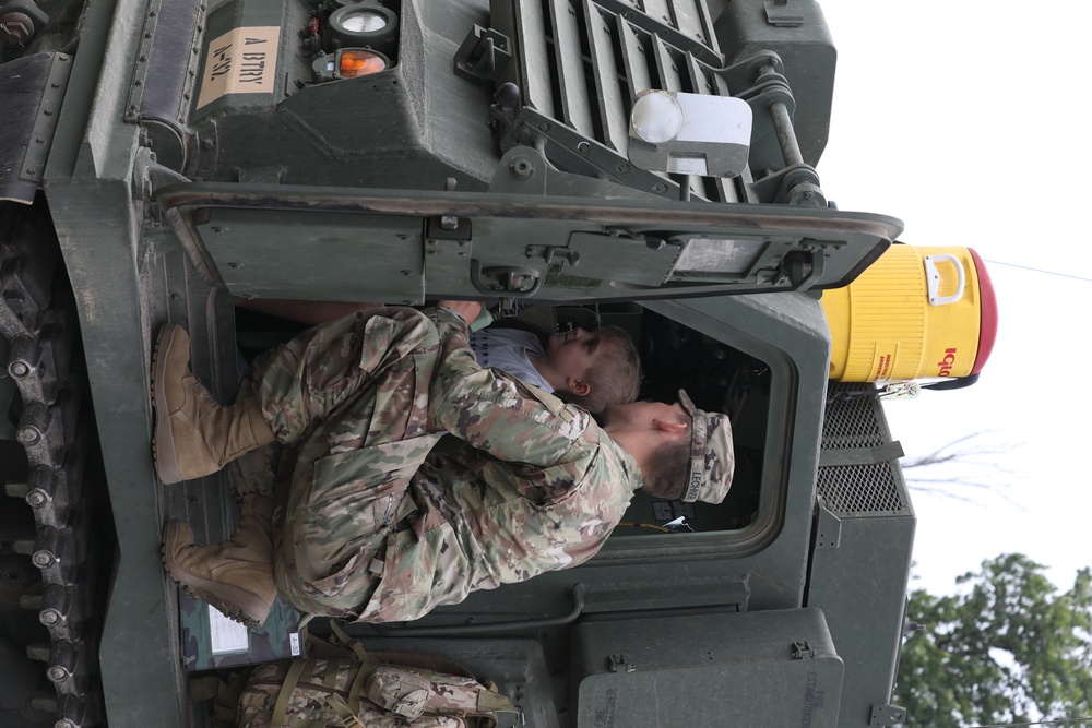 Soldier from 1-147 FA gives Ethan Manson a tour of M270A1 MLRS