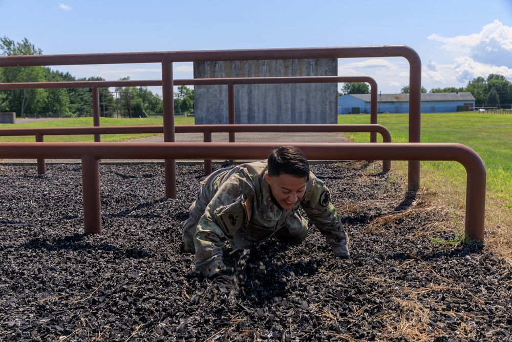 Maj. Nicole Dallocchio crawls under an obstacle