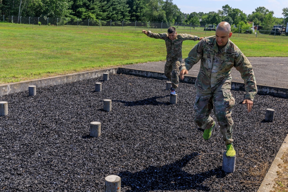 Staff Sgt. Devin Crawford and Col. Ryan “MZ” Montanez  step over an obstacle