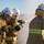 Talisman Sabre 21: U.S., Australian forces perform bilateral fuel training Three firefighters in full protective gear are operating a fire hose outdoors in an open, dry field setting. They are working together to control a high-pressure water stream, suggesting a training exercise or active firefighting operation. The scene appears to take place during daylight under clear skies.