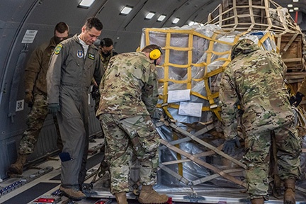 Tech. Sgt. Chris Davis, a boom operator from the 916th Air Refueling Wing, assists 67th Aerial Port Squadron reservists with locking a pallet down in a KC-46A Pegasus