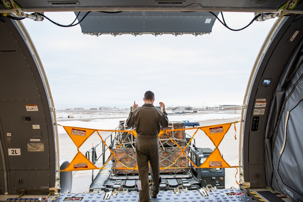 Tech. Sgt. Chris Davis, a boom operator from the 916th Air Refueling Wing, marshals a Tunner 60K aircraft cargo loader during a training exercise