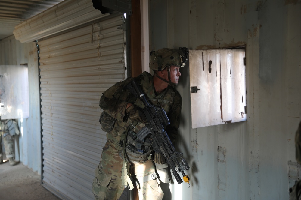 A Soldier assigned to the 45th Infantry Brigade Combat Team scans an alleyway for members of the opposing force