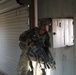 A Soldier assigned to the 45th Infantry Brigade Combat Team scans an alleyway for members of the opposing force