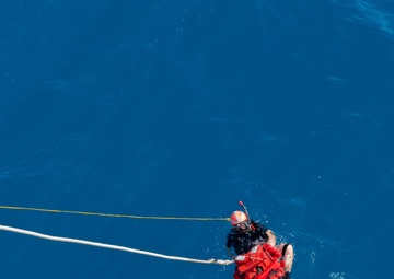 SAR swimmer retrieves "Oscar" during man overboard training.