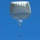 A parachutist is descending under a large, round silver/white military-style parachute against a clear blue sky. The jumper appears to be carrying equipment, with a separate load suspended below them on a lowering line. The image is taken from a ground-level upward angle, providing a clear view of the canopy and jumper.