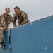 Sgt. Morgan Figgs helps teammate 1st Lt. Joshua Moeller over an obstacle