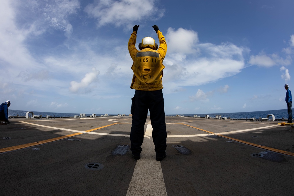 USS Sioux City Sailor Directs an MH-60S Seahawk Helicopter