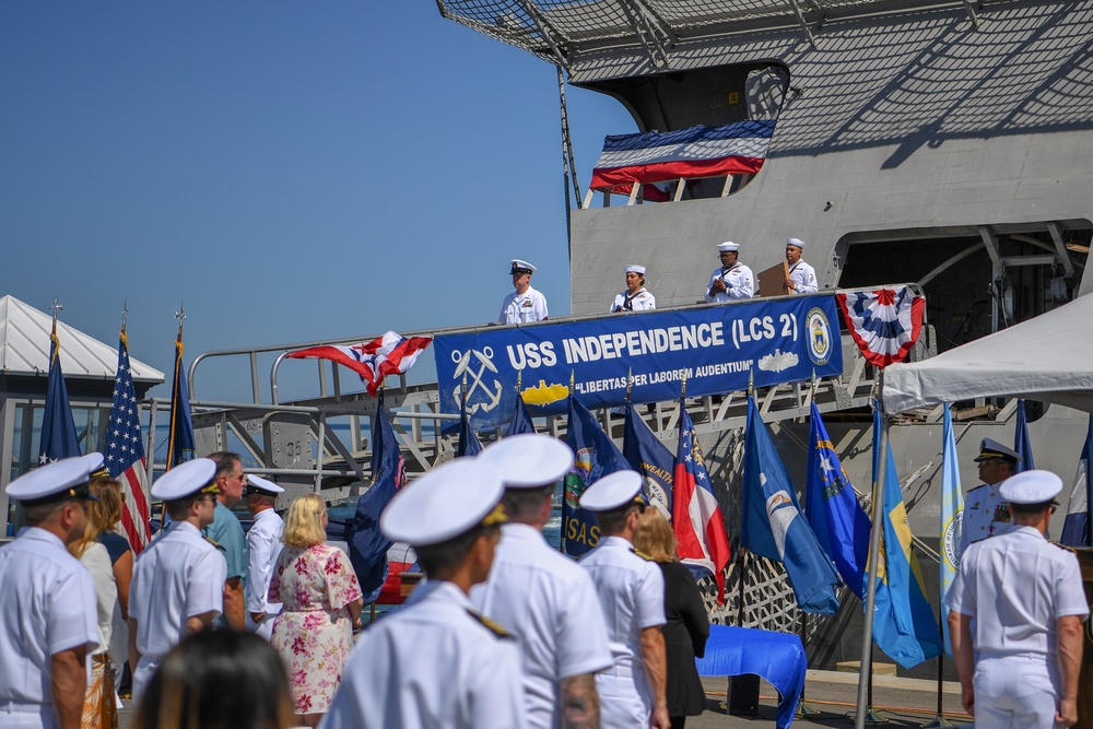 Ship's crew deliver the ensign and commissioning pennant during the decommissioning of USS Independence (LCS 2)