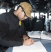 Ensign Jason Brooks, from Cincinnati, Ohio, writes an entry into a log book