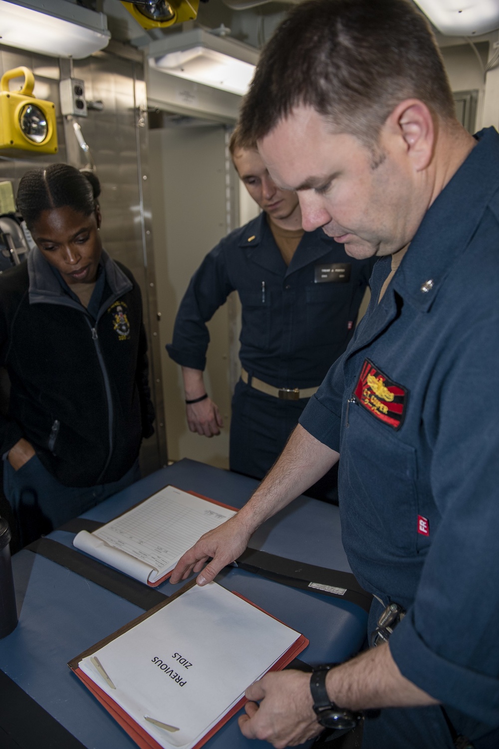 Cmdr. Charles Cooper, executive officer of USS Rafael Peralta (DDG 115), conducts an inspection with Sailors