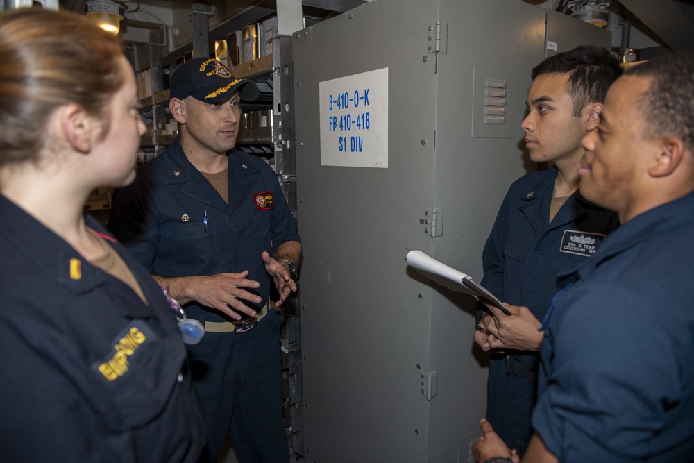 Cmdr. J.J. Murawski, commanding officer of USS Rafael Peralta (DDG 115), conducts an inspection with Sailors